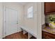 Inviting mudroom with bench seating, white door, coat hooks, and granite countertops on cabinetry at 16 Woodglen Dr, Clayton, NC 27527