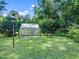 Lush backyard with greenhouse and bench nestled among mature trees and shrubbery at 1708 Lake Park Dr, Raleigh, NC 27612
