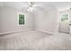 Spacious bedroom with neutral carpet, ceiling fan, and natural light from window at 1708 Lake Park Dr, Raleigh, NC 27612
