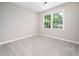 Carpeted bedroom with natural light pouring in from the large double window at 1708 Lake Park Dr, Raleigh, NC 27612