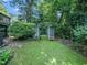 Backyard garden features a lattice archway over a short stone path through lush foliage at 1708 Lake Park Dr, Raleigh, NC 27612