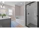 Modern bathroom featuring a tiled shower, soaking tub, and elegant vanity, illuminated by natural light at 174 Sequoia Dr, Louisburg, NC 27549