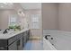 Bathroom boasts dual sinks, a large mirror, and a tub with tiled backsplash, blending style and functionality at 174 Sequoia Dr, Louisburg, NC 27549