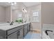 Bathroom boasts dual sinks, a large mirror, and a tub with tiled backsplash, blending style and functionality at 174 Sequoia Dr, Louisburg, NC 27549