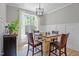 Dining area with natural light, wainscoting, and a modern chandelier at 174 Sequoia Dr, Louisburg, NC 27549