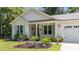 Close up of a home exterior showcasing a well-maintained garden and charming curb appeal at 174 Sequoia Dr, Louisburg, NC 27549