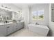 Elegant bathroom with double vanities, soaking tub, and modern fixtures for a spa-like experience at 20 Delia Ln, Pittsboro, NC 27312