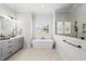 Modern bathroom featuring a soaking tub, marble floors, and a window with natural light at 20 Delia Ln, Pittsboro, NC 27312