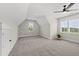 A large, carpeted bonus room with angled ceilings, windows and a ceiling fan at 20 Delia Ln, Pittsboro, NC 27312