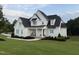 Beautiful new construction home with white siding, black roof, and manicured landscaping at 20 Delia Ln, Pittsboro, NC 27312