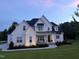 Charming two-story home with landscaped yard and inviting front porch at twilight at 20 Delia Ln, Pittsboro, NC 27312
