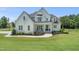 Elegant two-story farmhouse with a manicured lawn, stylish porch, and modern design elements at 20 Delia Ln, Pittsboro, NC 27312