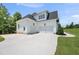 Three car garage with white siding and clean, concrete driveway on a sunny day at 20 Delia Ln, Pittsboro, NC 27312