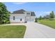 Three car garage with white siding and clean, concrete driveway with well manicured lawn at 20 Delia Ln, Pittsboro, NC 27312