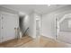 Upstairs hallway with hardwood floors, showcasing the transition to multiple rooms and a sunlit window at 20 Delia Ln, Pittsboro, NC 27312