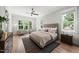 Bright main bedroom with large windows, hardwood floors, a ceiling fan, and cozy seating at 20 Delia Ln, Pittsboro, NC 27312