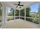 A spacious screened porch with black railings and a ceiling fan provides an outdoor retreat with views of the lush yard at 20 Delia Ln, Pittsboro, NC 27312