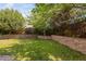 Lush backyard showcasing a well-maintained lawn and a charming stone retaining wall with mature trees at 200 Woodvale Way, Fuquay Varina, NC 27526