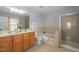 Bathroom with a double sink vanity, soaking tub, and glass-enclosed shower at 200 Woodvale Way, Fuquay Varina, NC 27526