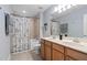 Well-lit bathroom featuring double sinks and a tub-shower combination with unique shower curtain at 200 Woodvale Way, Fuquay Varina, NC 27526