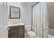 Bathroom vanity with granite countertop, undermount sink, and decorative floral shower curtain at 200 Woodvale Way, Fuquay Varina, NC 27526