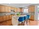 Spacious kitchen featuring wood cabinets, granite countertops, tile backsplash, and a center island with seating at 200 Woodvale Way, Fuquay Varina, NC 27526