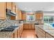Gourmet kitchen featuring granite counters, tile backsplash, gas cooktop, and access to the outdoor patio at 200 Woodvale Way, Fuquay Varina, NC 27526