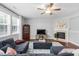 Cozy living room with fireplace, TV, dark wood floors, and comfortable blue sectional sofa at 200 Woodvale Way, Fuquay Varina, NC 27526