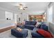 Open concept living room flows into kitchen with a large blue sofa and ceiling fan at 200 Woodvale Way, Fuquay Varina, NC 27526
