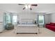 Comfortable primary bedroom with natural light from large windows, a ceiling fan, and a cozy couch at 200 Woodvale Way, Fuquay Varina, NC 27526