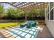 Backyard patio featuring a pergola, stone wall, and comfortable outdoor seating at 200 Woodvale Way, Fuquay Varina, NC 27526