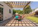 Outdoor patio area with a wooden pergola, brick pavers, and a dining set for outdoor entertaining and relaxation at 200 Woodvale Way, Fuquay Varina, NC 27526