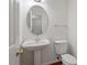 Bathroom with pedestal sink, toilet, oval mirror and wood floors at 205 Mint Hill Dr, Cary, NC 27519