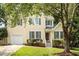 Traditional home with a well-kept lawn, an attached garage, and mature trees in the front yard at 205 Mint Hill Dr, Cary, NC 27519