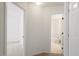 Hallway leading to a bedroom and a bathroom with white fixtures and neutral tile at 205 Mint Hill Dr, Cary, NC 27519