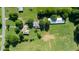 Aerial view of a quaint home and outbuildings surrounded by verdant fields and mature trees at 2081 Stone Street Ext, Mebane, NC 27302