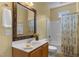 Bright bathroom featuring a wood-framed mirror, sink, and bathtub with shower at 2104 Brockfield Ct, Raleigh, NC 27614