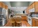 Open kitchen with stainless steel fridge, wooden cabinets, and view to living area at 2104 Brockfield Ct, Raleigh, NC 27614