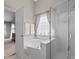 Corner soaking tub and glass shower with a frosted door at 2104 Brockfield Ct, Raleigh, NC 27614