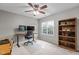 Home office with a wooden bookshelf, ceiling fan, and large windows at 2104 Brockfield Ct, Raleigh, NC 27614