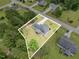 Aerial view of a home with a screened porch and garden plot, surrounded by a lush, green lawn and mature trees at 220 Oxfordshire Dr, Fuquay Varina, NC 27526