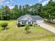 Beautiful house showcasing its spacious lawn, driveway, and the surrounding mature trees at 220 Oxfordshire Dr, Fuquay Varina, NC 27526