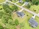 Aerial view of a home with a screened porch and garden plot, surrounded by a lush, green lawn and mature trees at 220 Oxfordshire Dr, Fuquay Varina, NC 27526