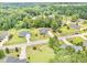An aerial shot showcases a charming home with a long driveway nestled amongst lush greenery in a serene neighborhood at 220 Oxfordshire Dr, Fuquay Varina, NC 27526