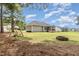 Open backyard view with a swing set, fire pit, and distant covered porch at 220 Oxfordshire Dr, Fuquay Varina, NC 27526