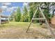 Large backyard with mature trees, a swing set, and ample space for outdoor activities at 220 Oxfordshire Dr, Fuquay Varina, NC 27526