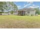 Spacious backyard featuring a lawn, mature trees, swing set, and garden beds at 220 Oxfordshire Dr, Fuquay Varina, NC 27526