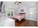 Bedroom featuring hardwood floors, large window, and a ceiling fan with a light fixture at 220 Oxfordshire Dr, Fuquay Varina, NC 27526