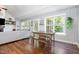 Bright living room with hardwood floors and view to the outside from two large windows and includes a dining table at 220 Oxfordshire Dr, Fuquay Varina, NC 27526