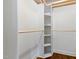 Walk-in closet with hardwood floors, custom shelving, and hanging rods for optimal storage at 220 Oxfordshire Dr, Fuquay Varina, NC 27526